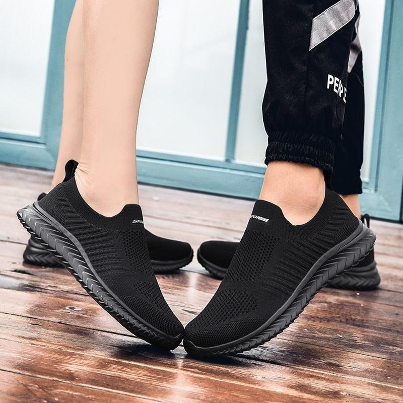 Stevvex black knit slip-on sneakers with ribbed outsole, pair on a wooden deck on Tampa Home & Garden Store