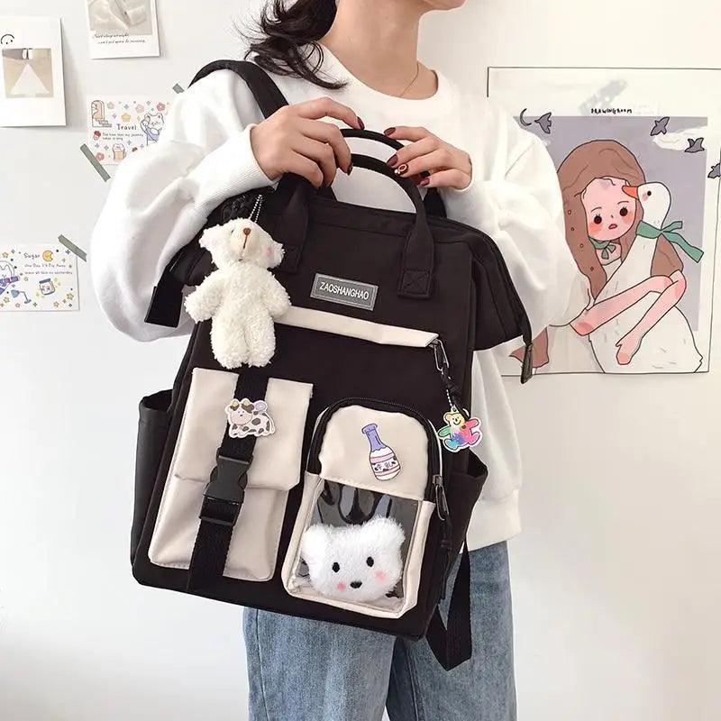 Stevvex black school backpack with beige front pockets, plush teddy bear and cat keychains on Tampa Home & Garden Store