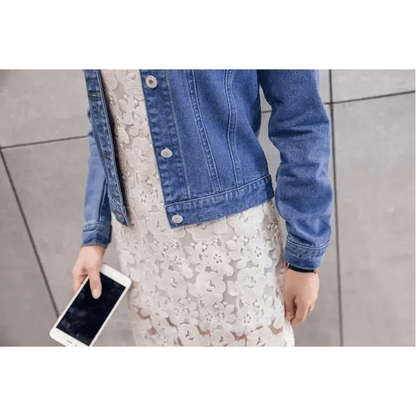 Stevvex blue trucker denim jacket worn over white lace dress, woman holding smartphone on Tampa Home & Garden Store