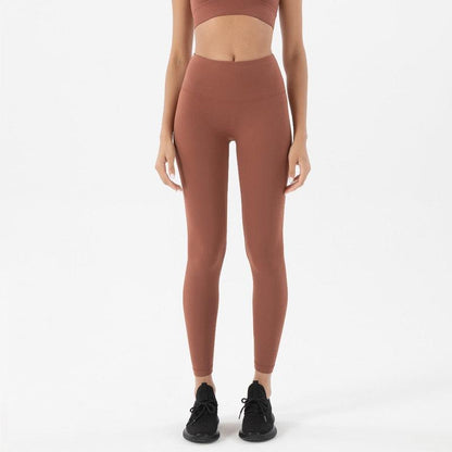 Brown high-waisted yoga leggings on a model with black sneakers on Tampa Home & Garden Store