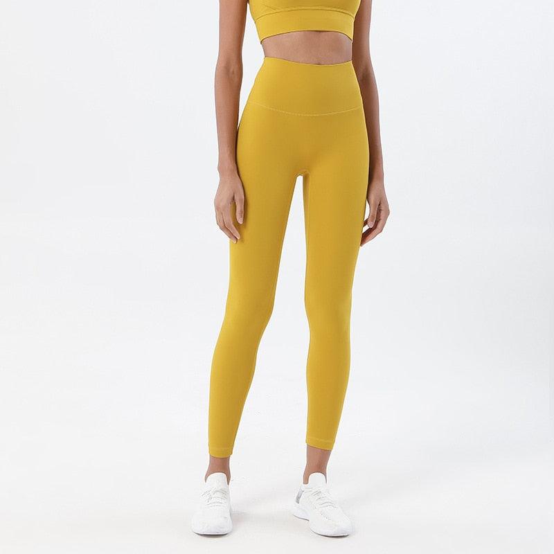 Yellow high-waisted yoga leggings with snug fit on model, ankle-length sports pants on Tampa Home & Garden Store