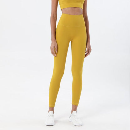 Yellow high-waisted yoga leggings with snug fit on model, ankle-length sports pants on Tampa Home & Garden Store