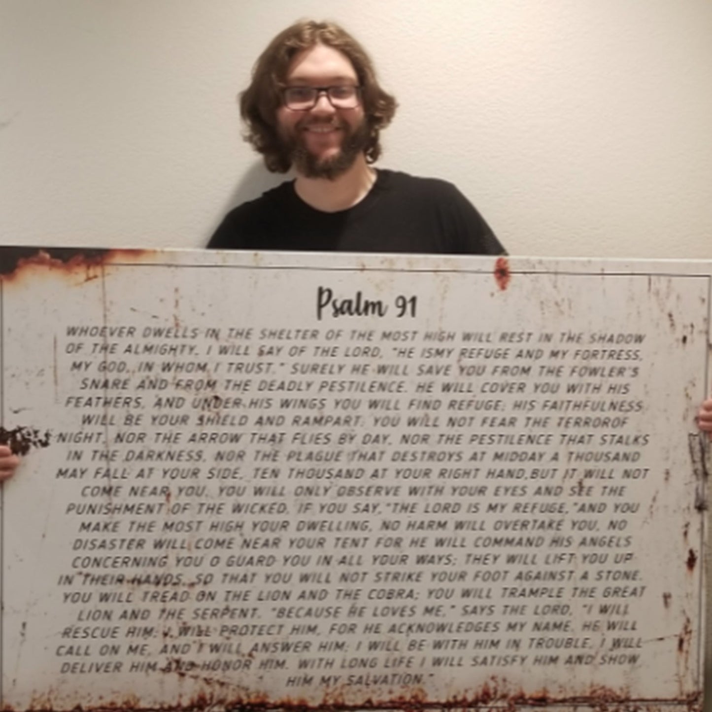 Psalm 91 canvas wall art by Tailored Canvases with rust-stain edges, held by a smiling man on Tampa Home & Garden Store