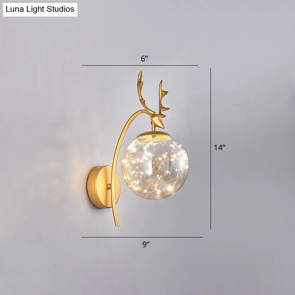 Brass-finish antler wall sconce with glass globe and warm string lights 14in tall on Tampa Home & Garden Store