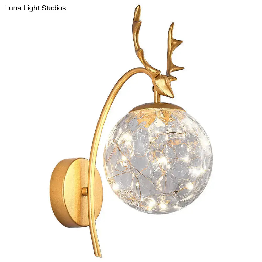 Black Antler Wall Sconce by Decorbites with a curved gold-tone arm and glass globe on Tampa Home & Garden Store