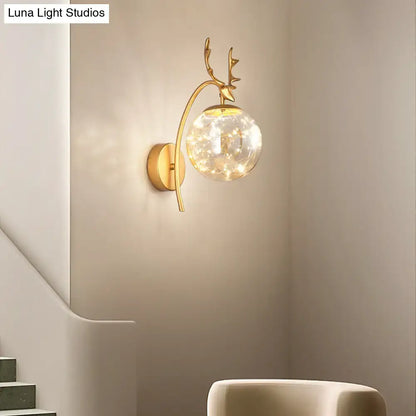 Black Antler Wall Sconce by Decorbites with gold-tone antlers and a glass globe of warm LEDs on Tampa Home & Garden Store