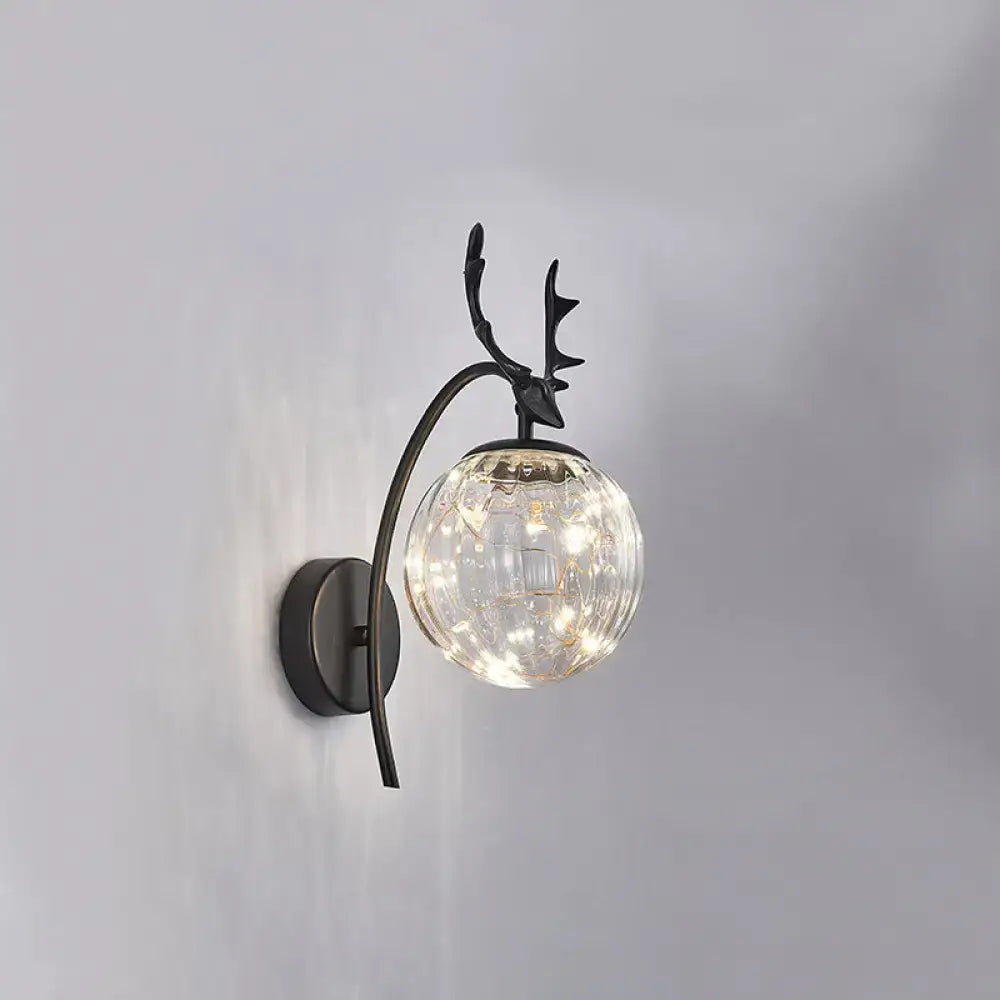 Decorbites Black Antler Wall Sconce with clear glass globe and warm LED lights on Tampa Home & Garden Store