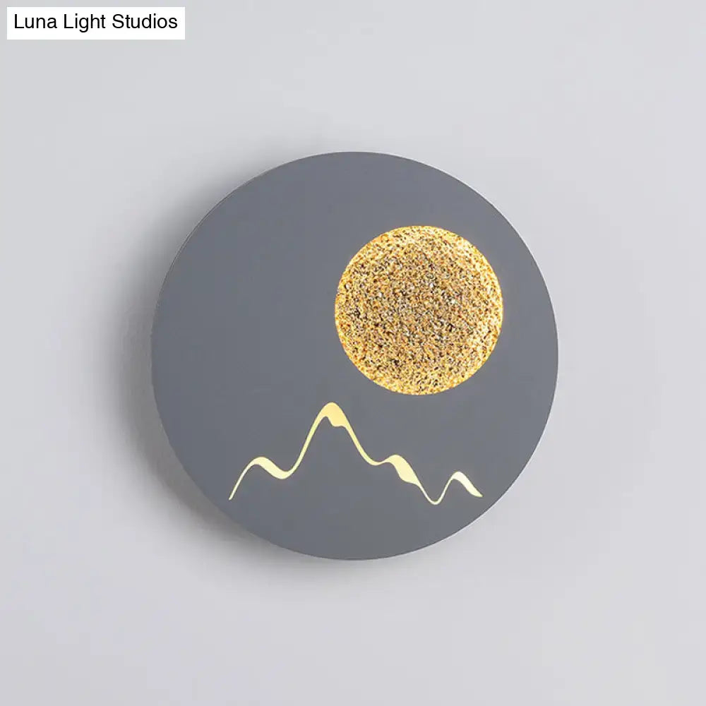 Metallic Mountain Wall Light with gray circular backplate and gold sun and mountain accents on Tampa Home & Garden Store