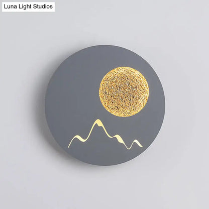 Metallic Mountain Wall Light with gray circular backplate and gold sun and mountain accents on Tampa Home & Garden Store