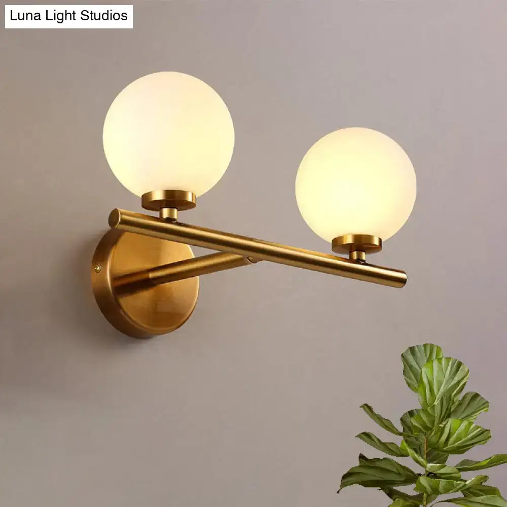 Brass globe wall sconce with dual frosted glass globes on a horizontal bar wall mount Decorbites on Tampa Home & Garden Store