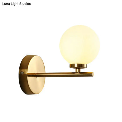 Brass globe compact wall sconce with frosted glass orb and round backplate on Tampa Home & Garden Store