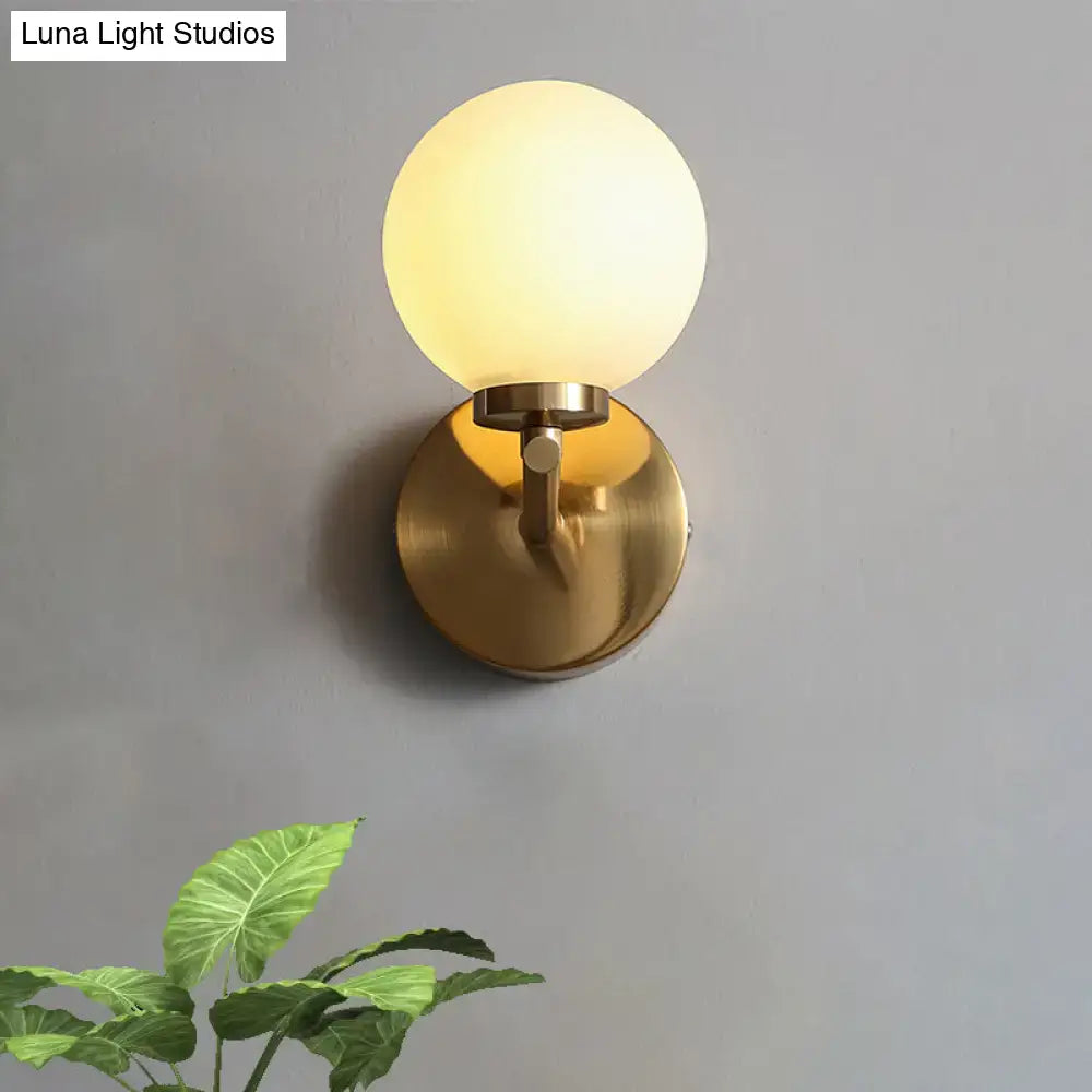 Brass globe compact wall sconce with frosted glass shade on brass backplate Decorbites on Tampa Home & Garden Store