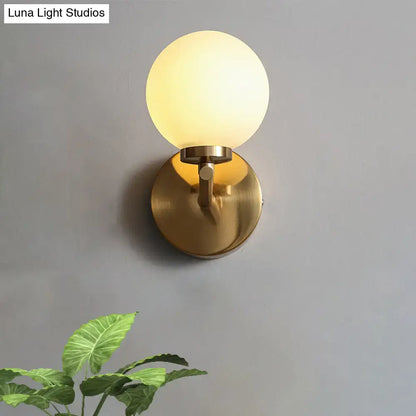 Brass globe compact wall sconce with frosted glass shade on brass backplate Decorbites on Tampa Home & Garden Store