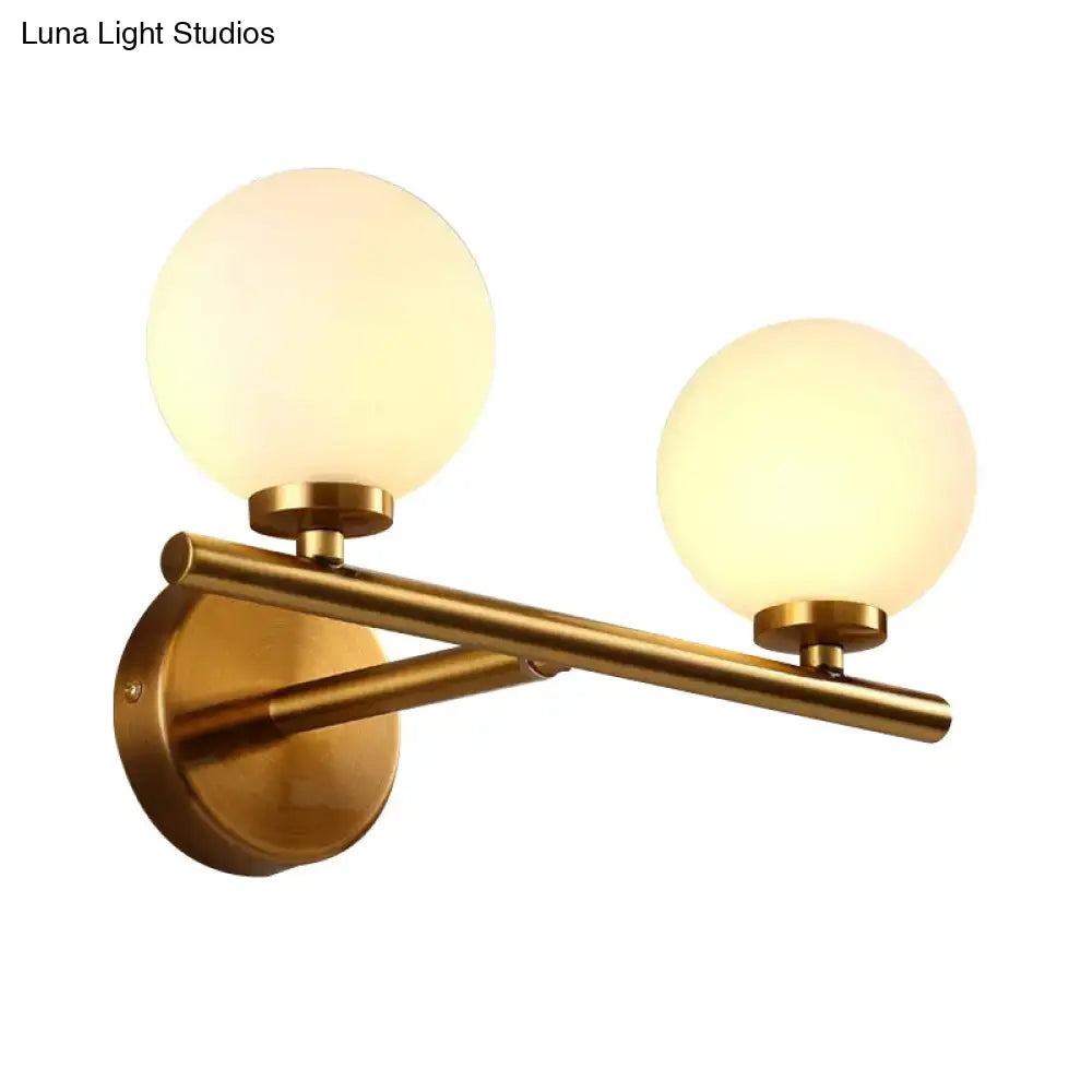 Brass Globe Compact Wall Sconce by Decorbites with twin frosted glass globes on a gold bar on Tampa Home & Garden Store