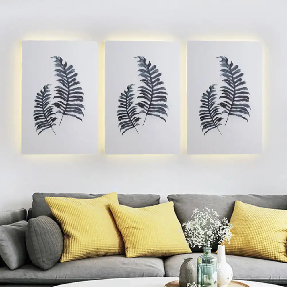 White Nordic Wall Sconce with fern print panels and subtle backlight above a sofa with cushions on Tampa Home & Garden Store