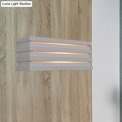 White louvered wall sconce with stacked horizontal slats and warm glow on Tampa Home & Garden Store