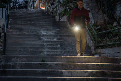 Fenix E08R UE multi-light EDC flashlight held by a man on stairs with bright beam on Tampa Home & Garden Store
