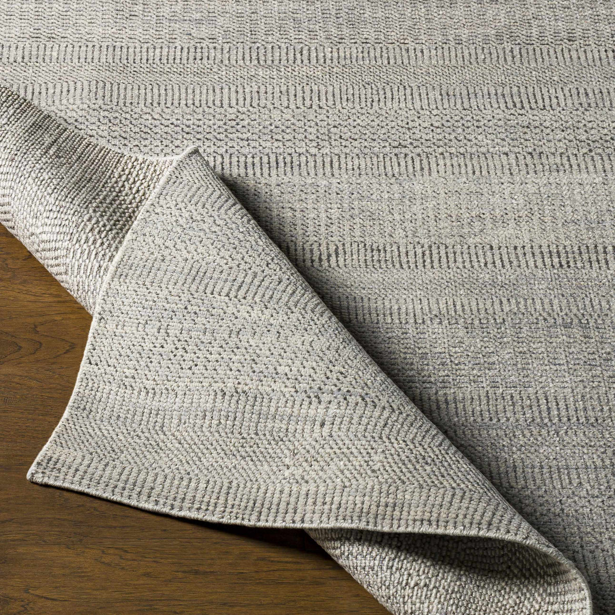 Ocate gray wool area rug by Boutique Rugs; textured gray pile on wood floor on Tampa Home & Garden Store