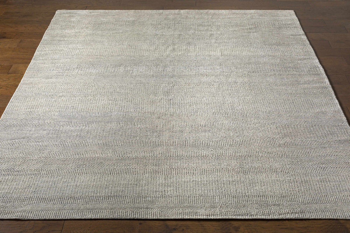 Ocate gray wool area rug with subtle striped texture by Boutique Rugs on wood floor on Tampa Home & Garden Store