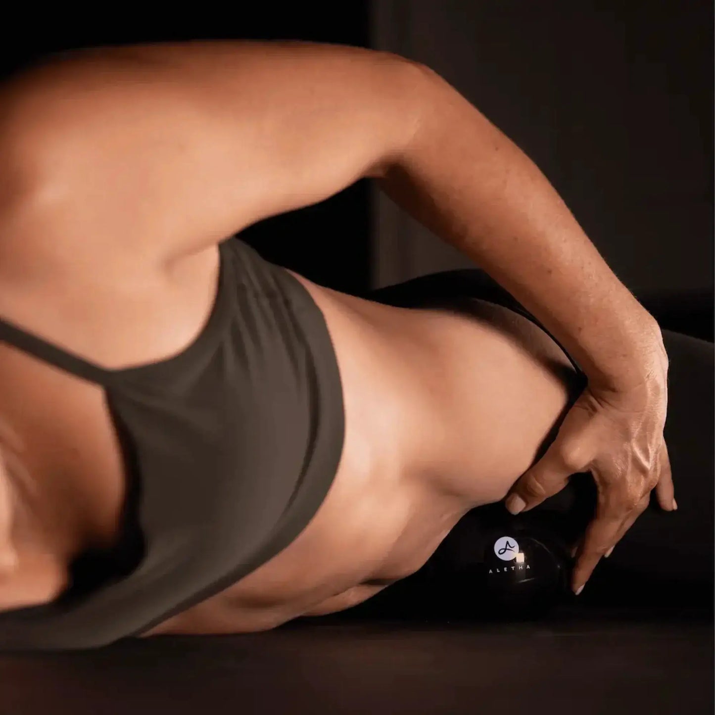 Orbit muscle release tool by Aletha Health; black device near forearm with dark tank top on Tampa Home & Garden Store