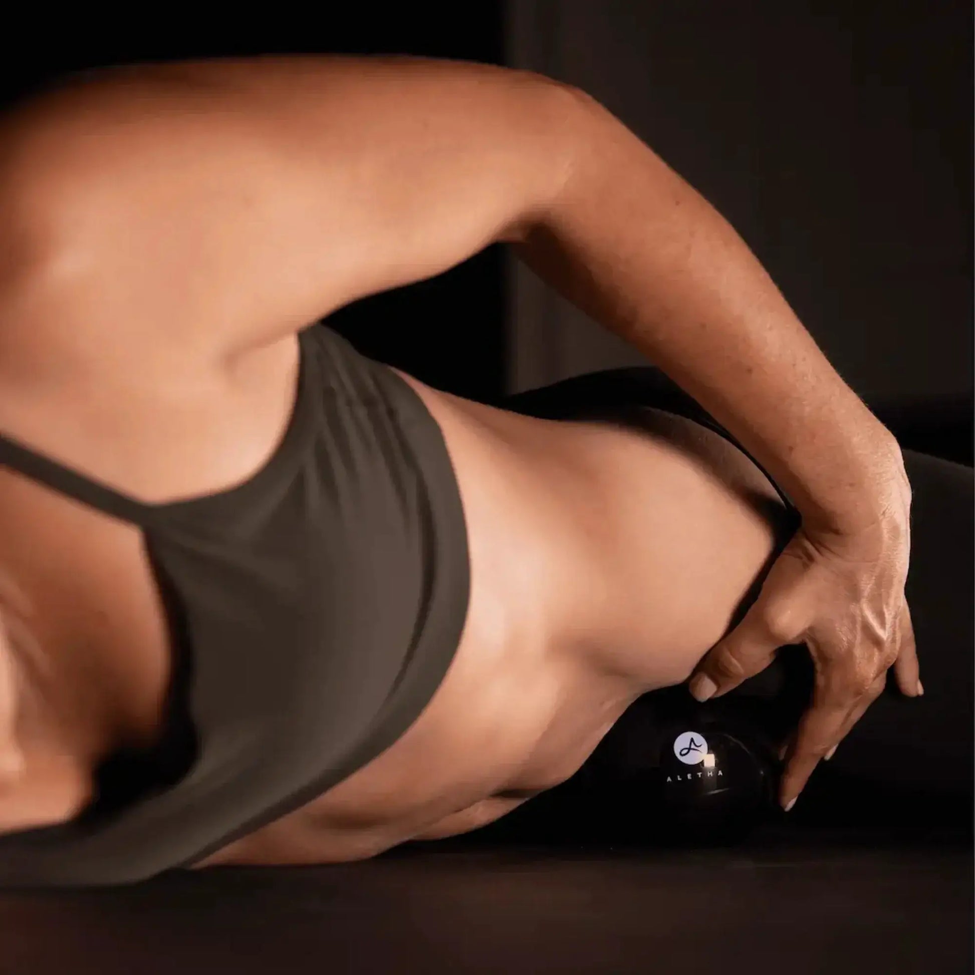 Orbit muscle release tool by Aletha Health; black device near forearm with dark tank top on Tampa Home & Garden Store