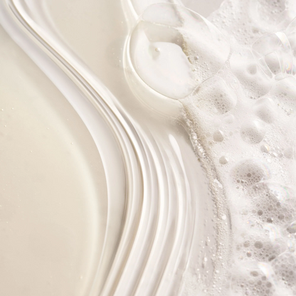 Oribe Serene Scalp Densifying Shampoo bottle with white creamy lather and bubbles on Tampa Home & Garden Store