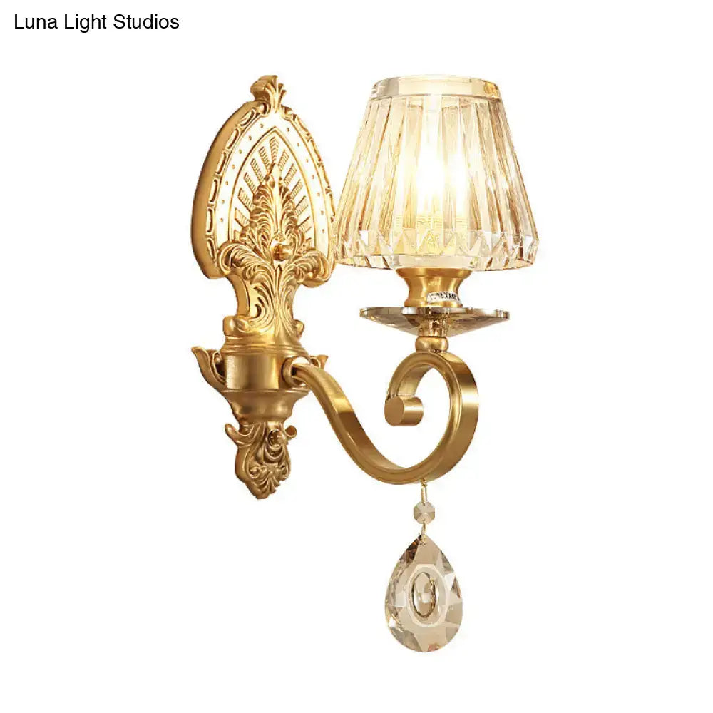 Gold crystal prismatic wall sconce with ornate backplate, curved arm, and teardrop crystal on Tampa Home & Garden Store