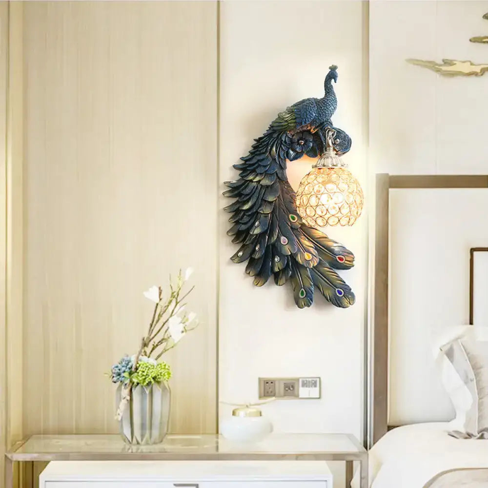 Blue Crystal Dome Wall Sconce with resin peacock feather design and warm orb light on Tampa Home & Garden Store