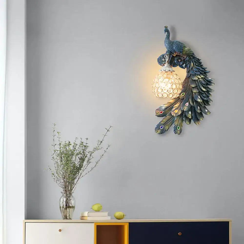 Blue crystal dome wall sconce with resin peacock design and warm glow on Tampa Home & Garden Store
