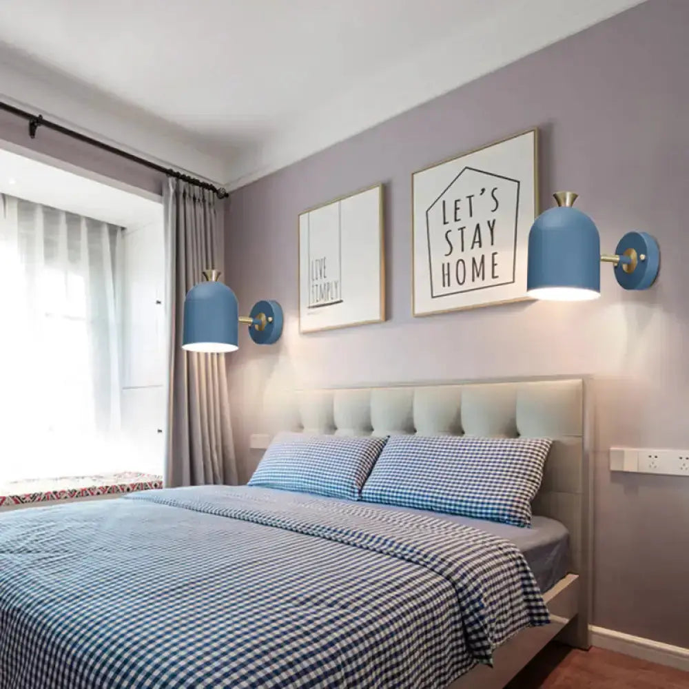 Blue macaron wall light sconces with brass accents flank a bed with blue gingham bedding on Tampa Home & Garden Store