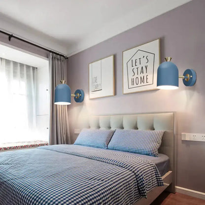 Blue macaron wall light sconces with brass accents flank a bed with blue gingham bedding on Tampa Home & Garden Store
