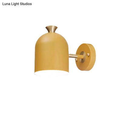 Mustard yellow brass macaron-style wall light sconce with round wall plate on Tampa Home & Garden Store