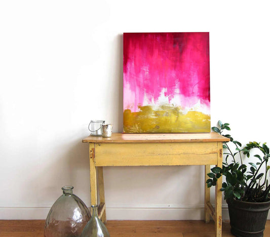 Pink and gold abstract premium art print by Mai Autumn, leaning on a wooden table on Tampa Home & Garden Store