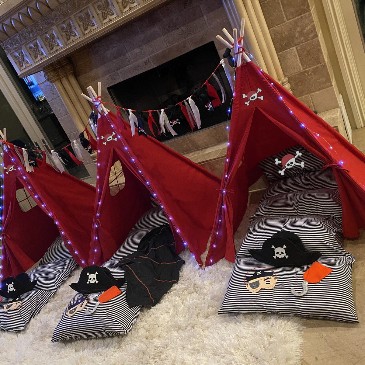 Pirate sleepover tent set with red tents, striped cushions, skull flags and fairy lights on Tampa Home & Garden Store