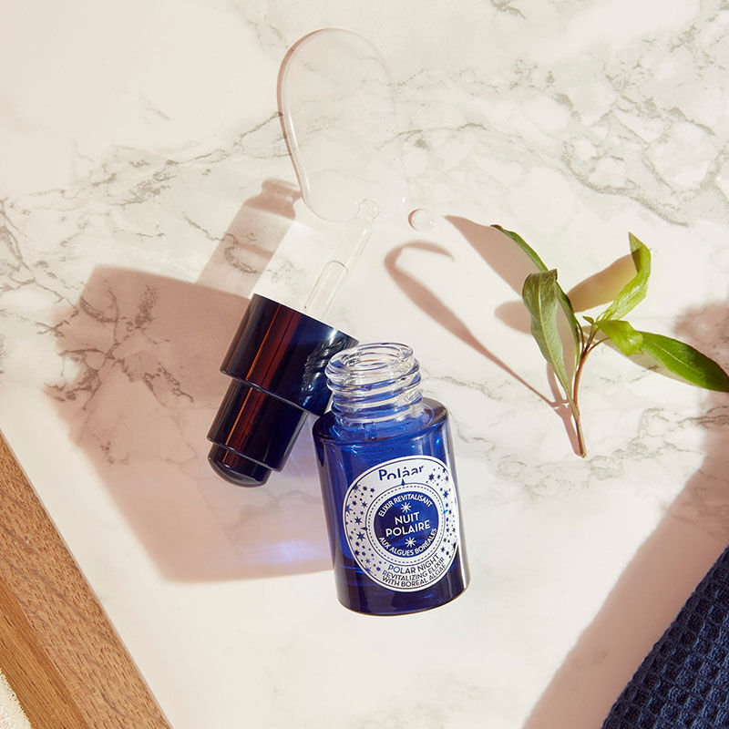 Polaar Night Revitalizing Elixir Glow Serum blue glass bottle with dropper on countertop on Tampa Home & Garden Store