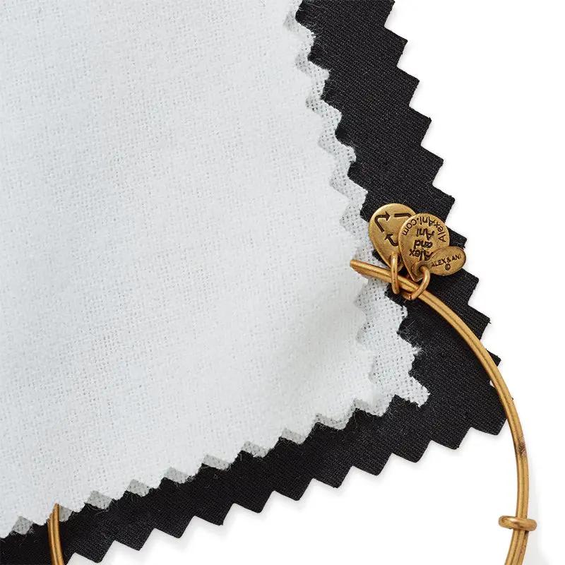 Jewelry polishing cloth white with black border; gold Alex and Ani bracelet with branded charms on Tampa Home & Garden Store