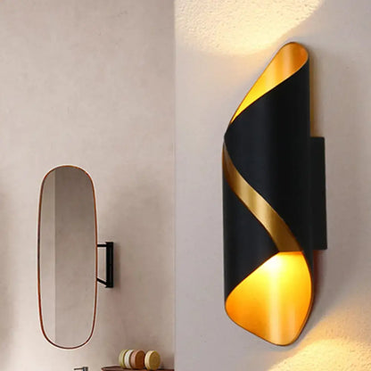 Decorbites Black Spiral Wall Sconce with gold spiral accent and warm amber light on wall on Tampa Home & Garden Store