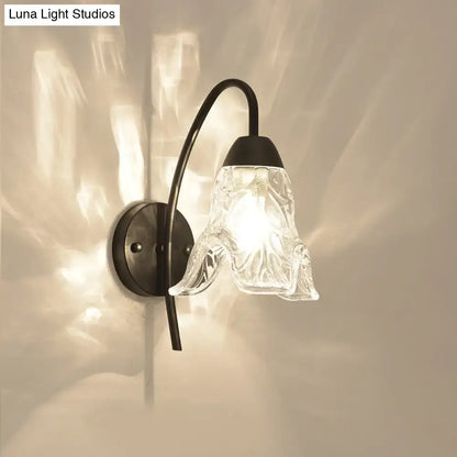 Black metal wall sconce with curved arm and clear crystal drum shade by Decorbites on Tampa Home & Garden Store