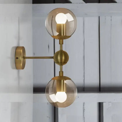 Brass amber globe sconce with dual glass orbs and wall mount by Decorbites on Tampa Home & Garden Store