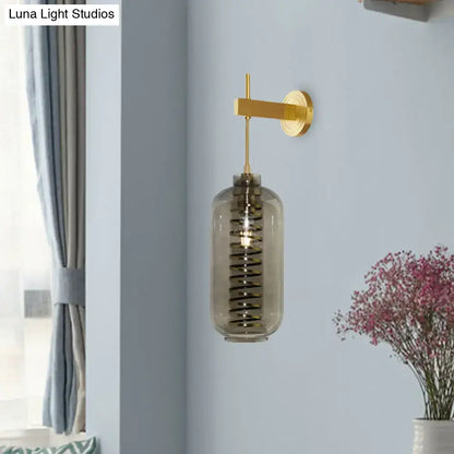 Brass gray glass sconce with cylindrical tinted shade by Decorbites on Tampa Home & Garden Store