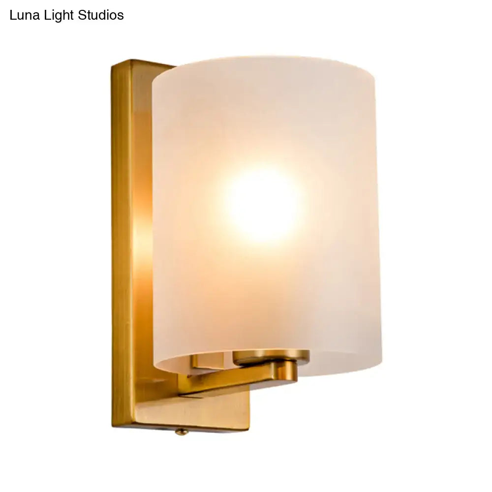 Brass Decorbites sconce with frosted cylindrical shade, wall mount on Tampa Home & Garden Store
