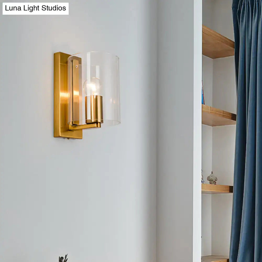 Brass finish clear glass wall sconce with cylindrical shade and exposed bulb on Tampa Home & Garden Store