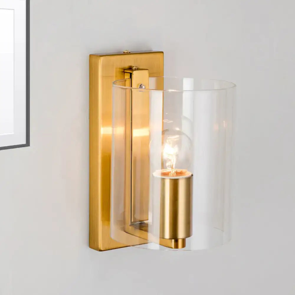 Brass clear glass wall sconce with cylindrical shade and gold backplate by Decorbites on Tampa Home & Garden Store