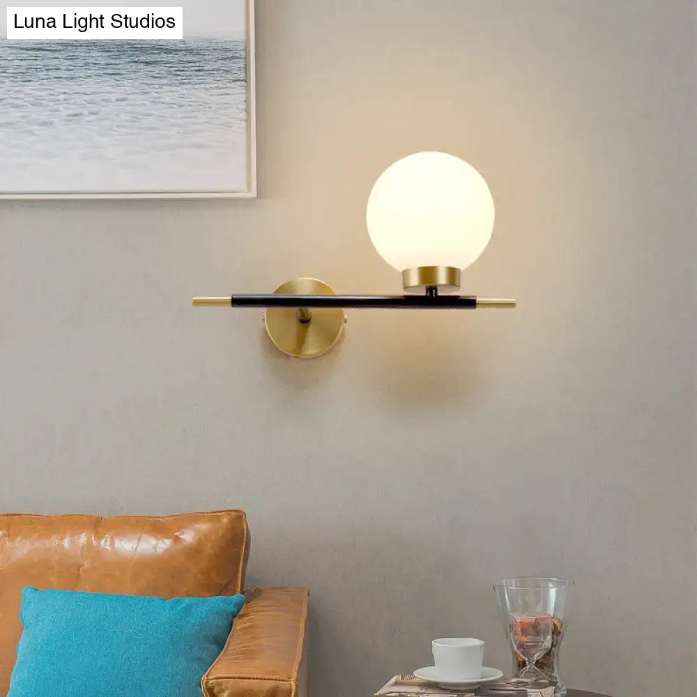 White Brass Sphere Sconce with frosted globe on a black and brass wall bar by Decorbites on Tampa Home & Garden Store