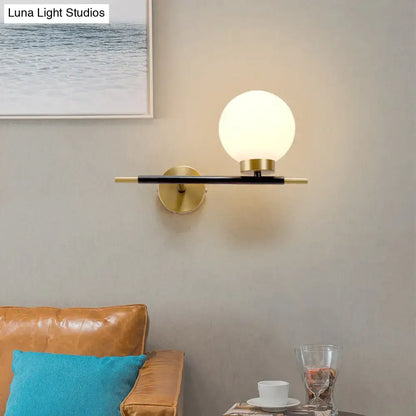 White Brass Sphere Sconce with frosted globe on a black and brass wall bar by Decorbites on Tampa Home & Garden Store