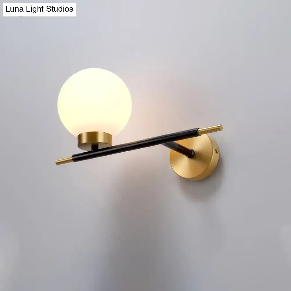 White Brass Sphere Sconce by Decorbites, wall-mounted with frosted globe and black-brass arm on Tampa Home & Garden Store