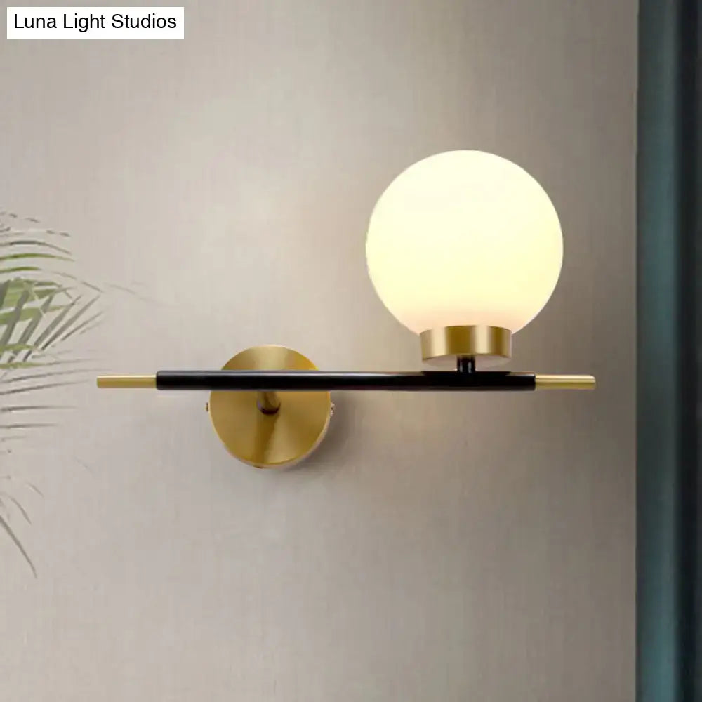 White brass sphere sconce by Decorbites with frosted globe and black brass arm wall mount on Tampa Home & Garden Store