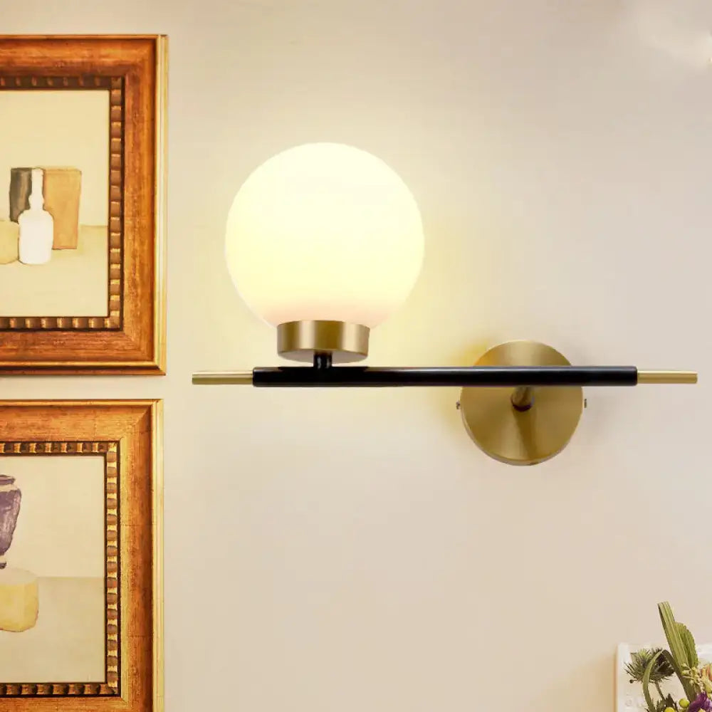 White Brass Sphere Sconce with frosted globe on a black brass bar and brass wall mount on Tampa Home & Garden Store