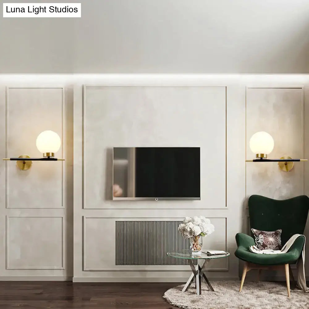 White brass sphere sconces pair with globe bulbs by Decorbites flanking a TV wall unit on Tampa Home & Garden Store