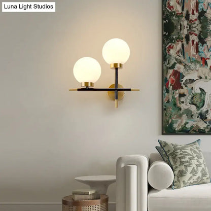 White Brass Sphere Sconce by Decorbites with dual frosted globes on wall in living room on Tampa Home & Garden Store